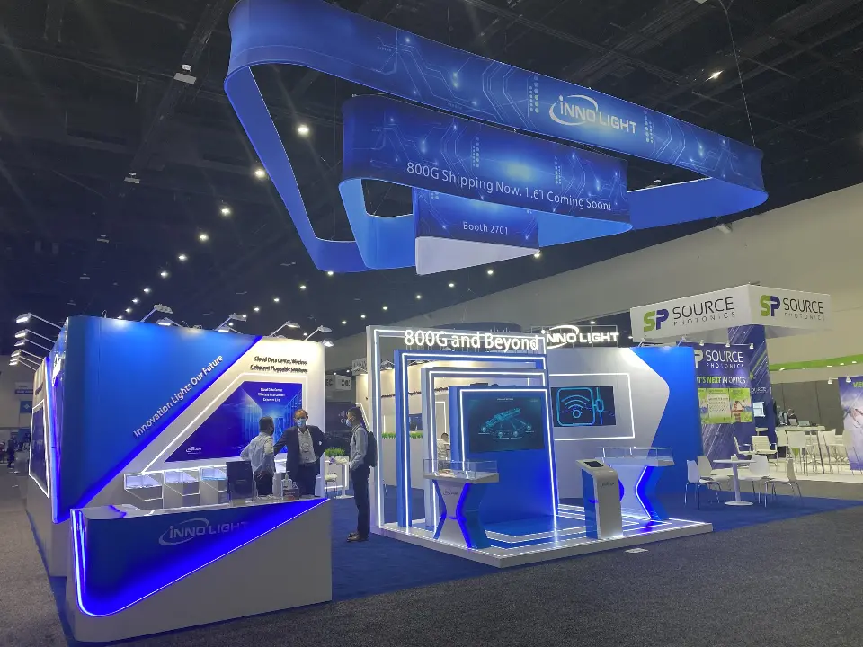 Angled view of the booth edge with blue graphics and lit showcase counters