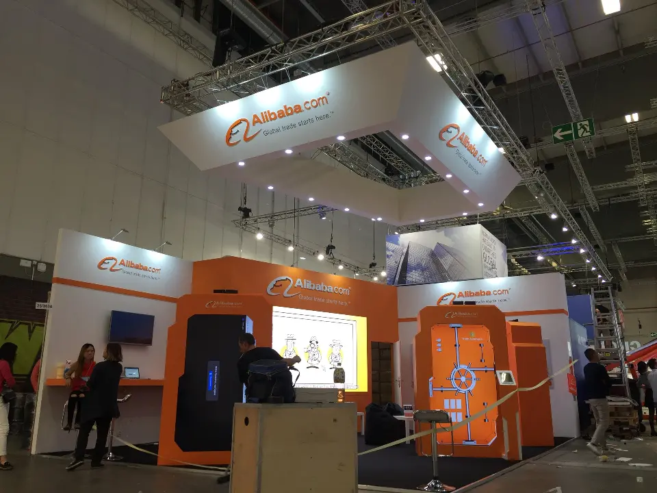 Finished Alibaba.com booth with orange door frames, lit screens and white header above