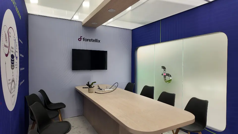 Meeting room with an oval wood-look table and black chairs