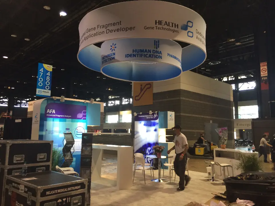 Advanced Fragment Analysis wall with monitor and white high tables beside the hanging ring sign