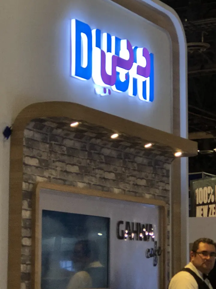 Glowing Dubai logo above a stone-look panel on a rounded wall