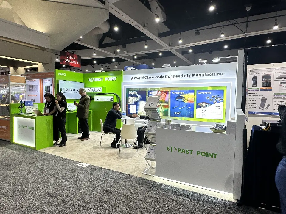 Wide view of the backlit connector graphic wall, round table and white logo counter