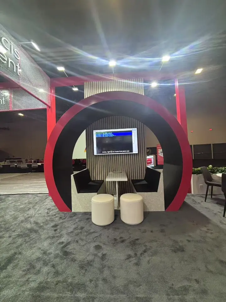 Close view inside a red ring pod with a mounted screen and white seats