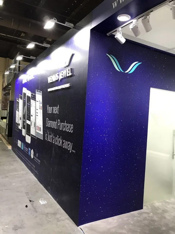 Navy corner with the V logo and lit fascia above an open doorway