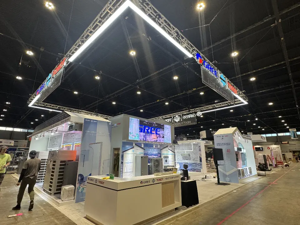 Reception counter with GREE logo under the lit triangular truss