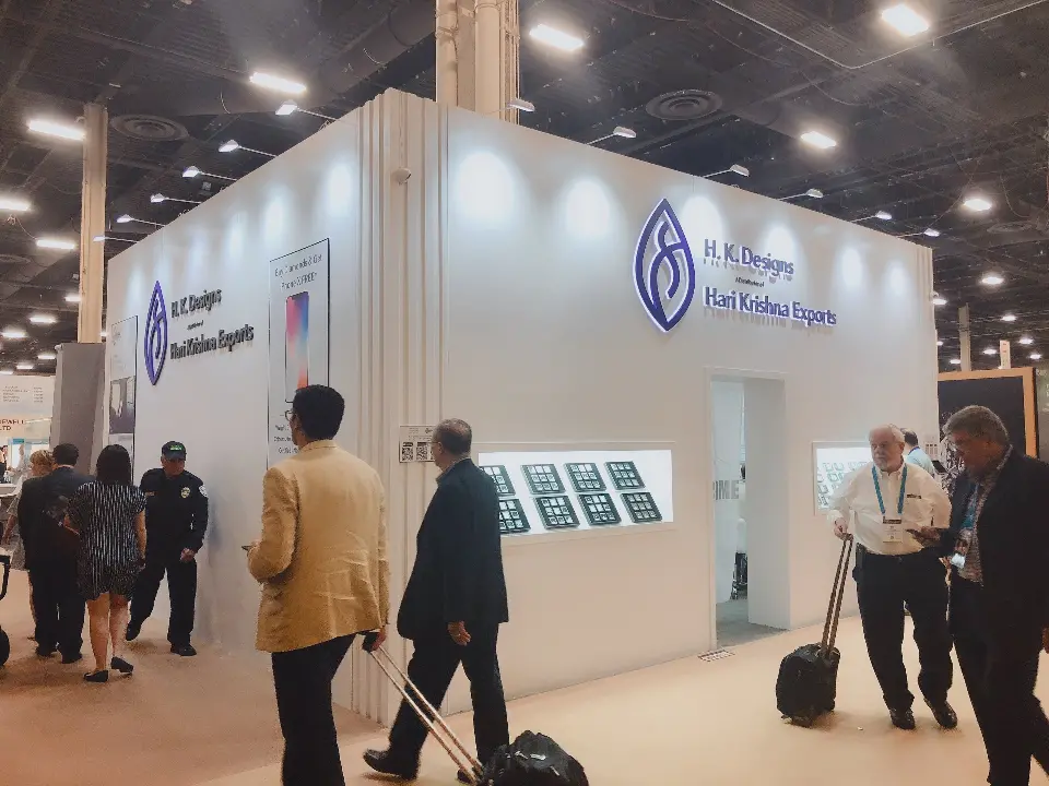 Visitors with rolling bags walking by the front wall and its backlit showcase windows