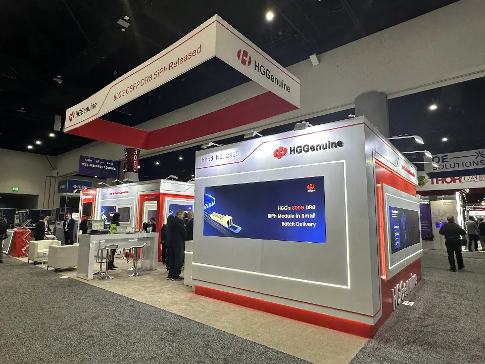 Wide view of the HGGenuine booth with square red header and backlit wall graphics