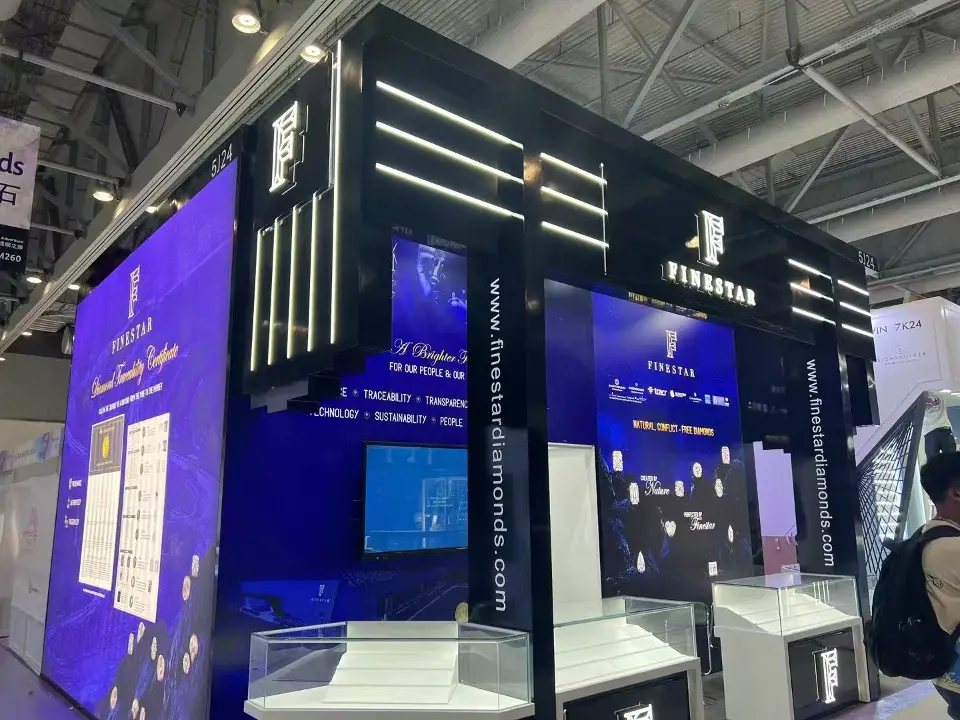 Corner of the Finestar booth with a large blue backlit wall and showcases