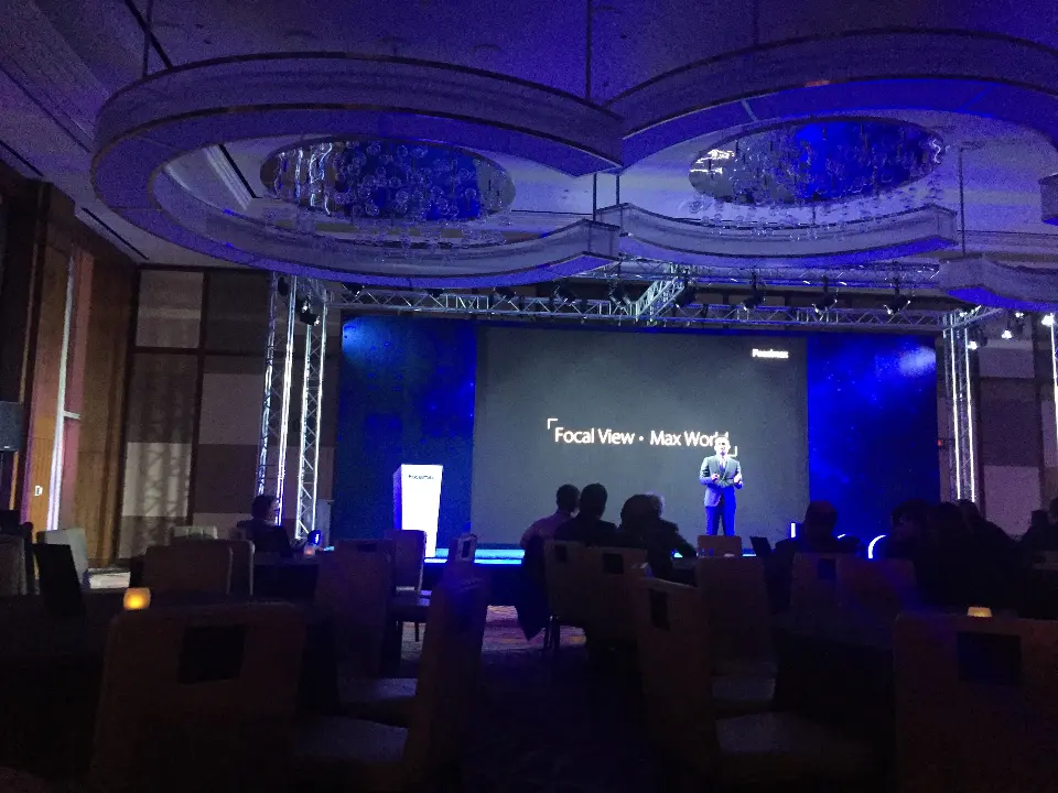 Speaker on stage with Focal View Max World shown on the video screen