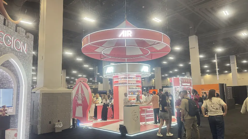View through a white arch toward the AIR booth and pink ring
