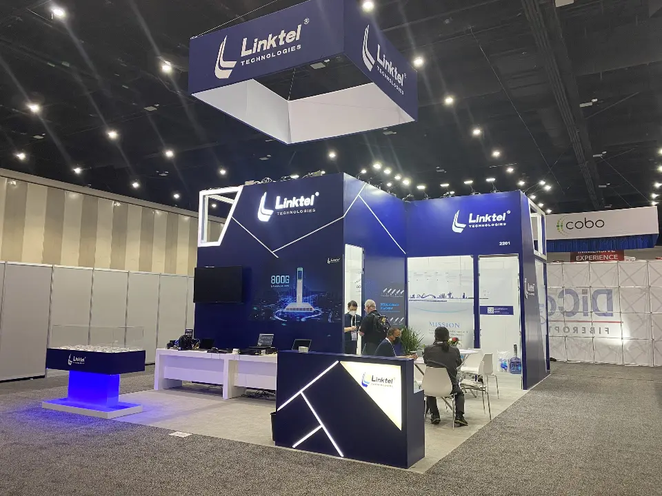Linktel booth front with geometric counters, seated visitors and navy fascia above