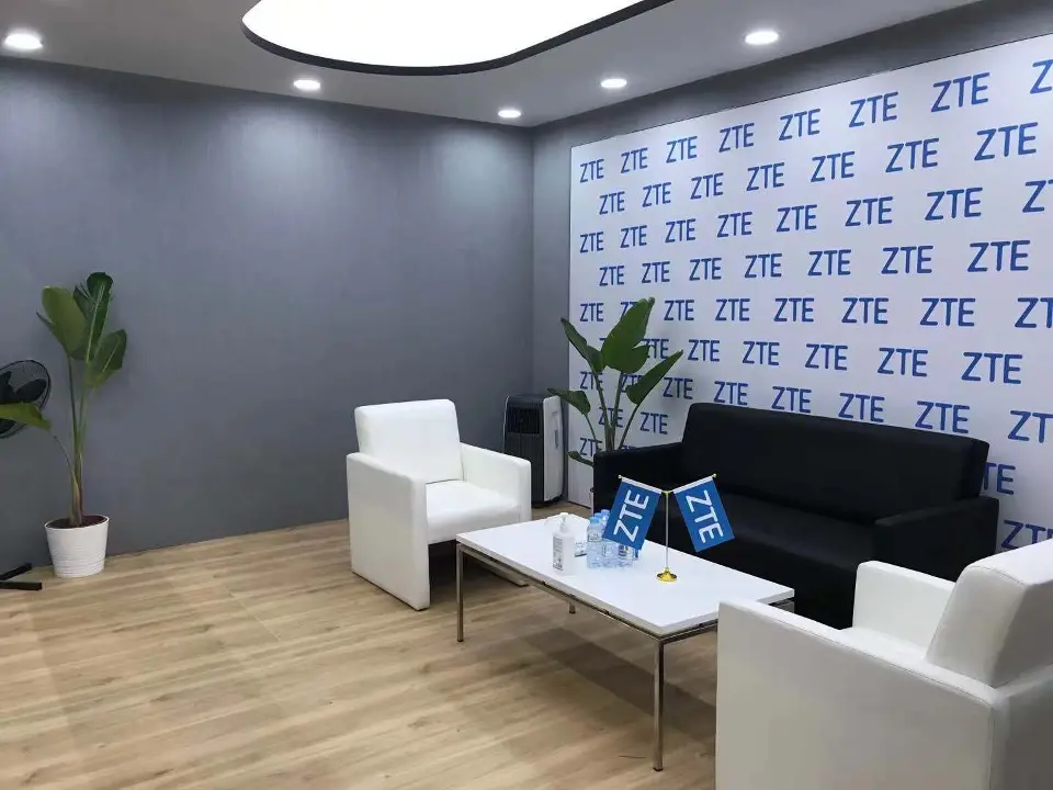 Private lounge with white sofa, coffee table and ZTE logo pattern wall