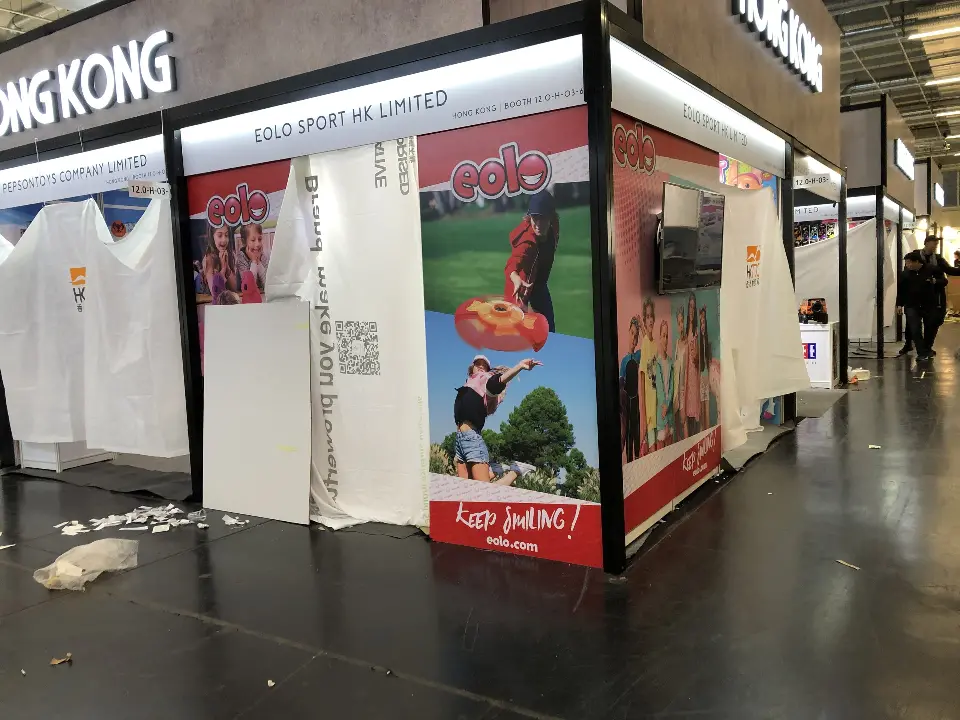 Booth corner wrapped in large printed sports graphics beside the aisle