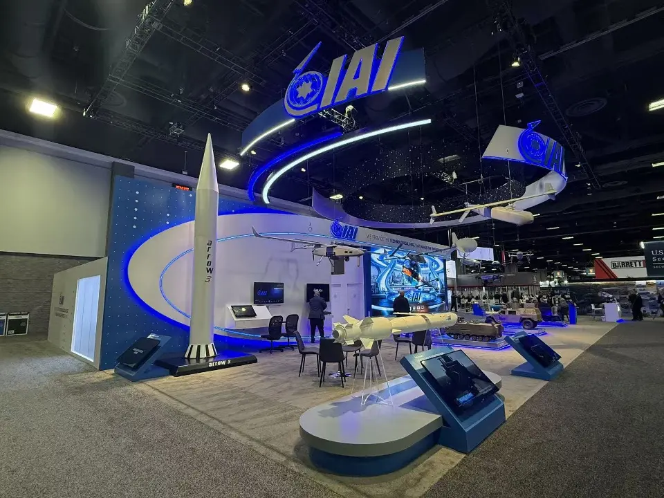 Missile models standing beside curved white display plinths under the blue IAI rings