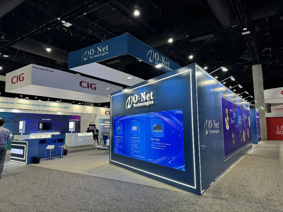 Corner of O-Net booth with framed blue graphic wall and light strips along its edges