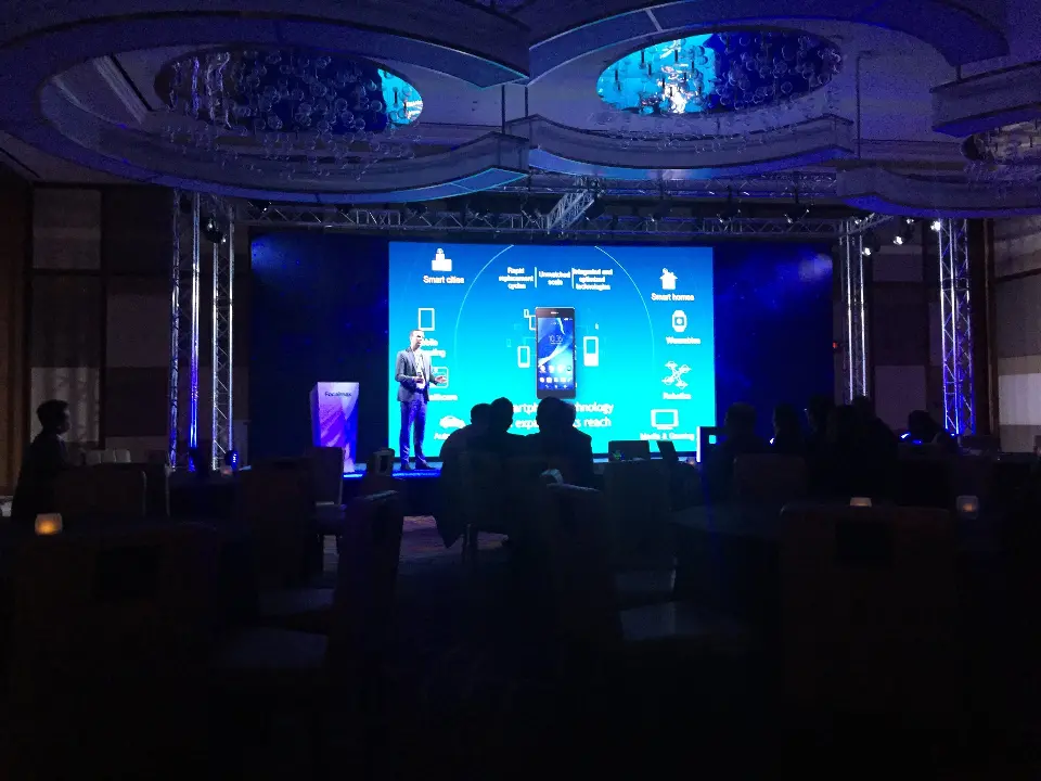 Stage presentation with phone and technology graphics on the blue screen