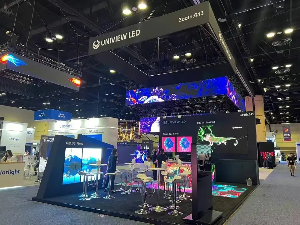 Black UNIVIEW LED booth with overhead header and a bright video ceiling above bar seating