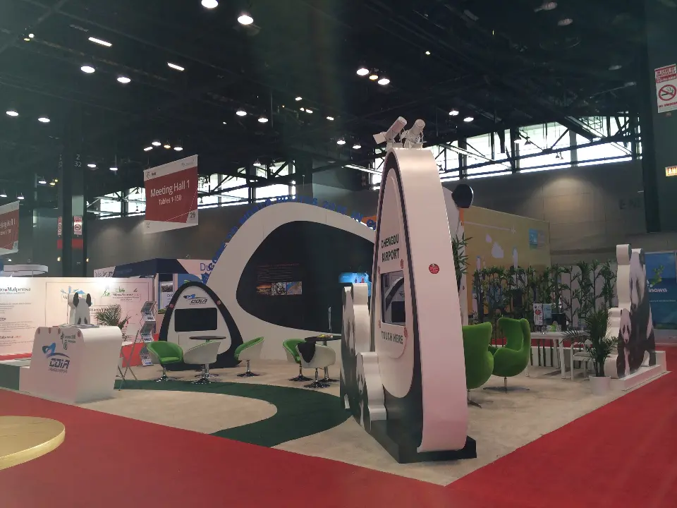 Side view of the Chengdu Airport stand with teardrop touch-screen kiosk, egg chairs and bamboo