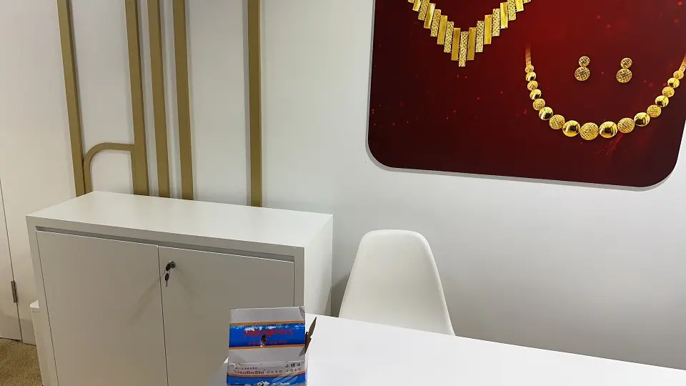 Lockable white cabinet with a gold necklace graphic on the wall behind