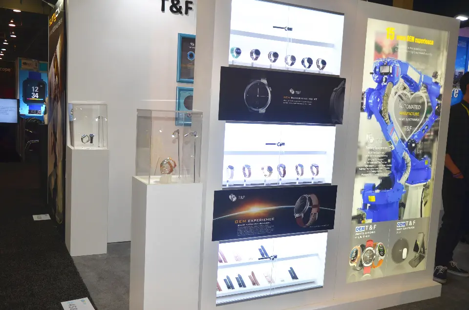 Lit shelves of smartwatches and straps beside a robot-arm lightbox and acrylic plinth cases